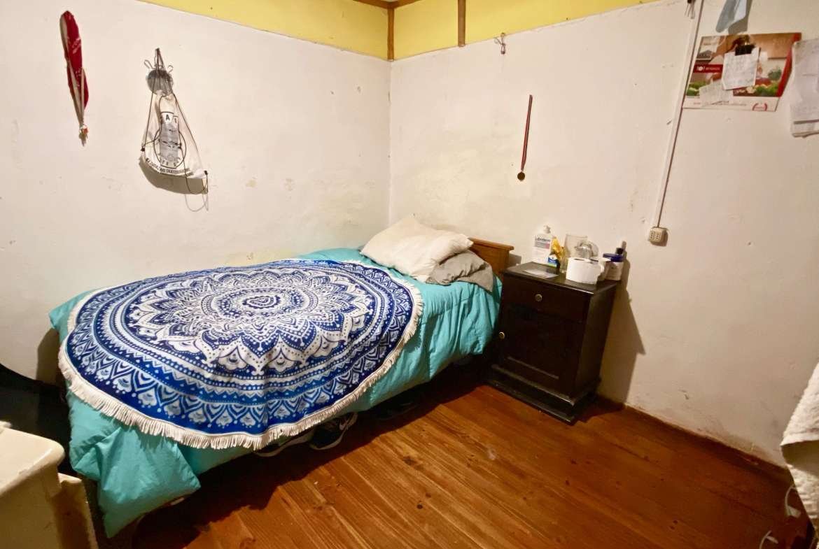 dormitorio con piso madera y muro de tabique